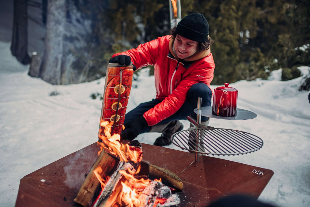 Gril rouge et noir avec grille en métal, équipement de cuisson extérieur.