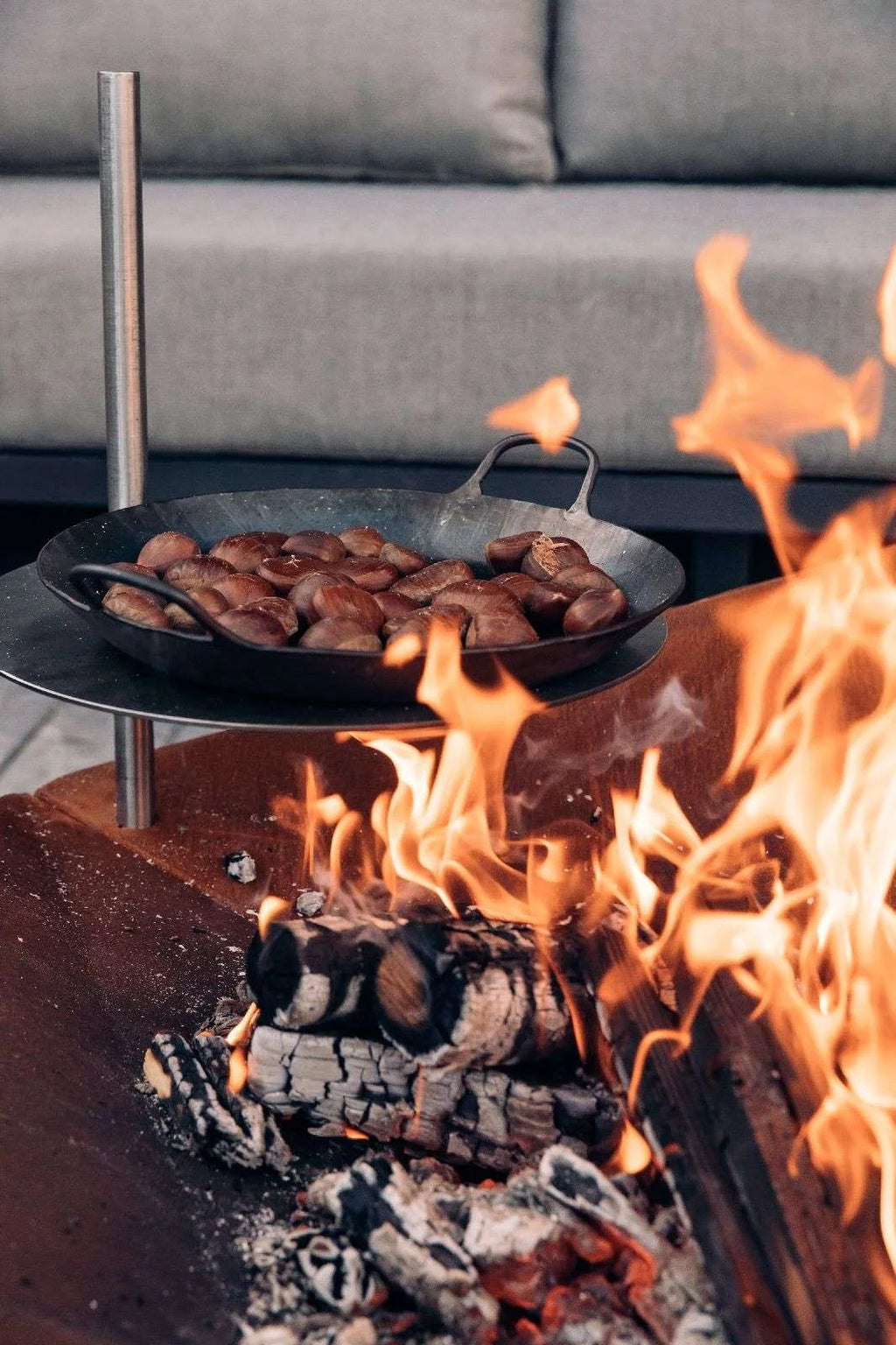 Poêle en fonte avec manche, cuisinant sur flamme ouverte.