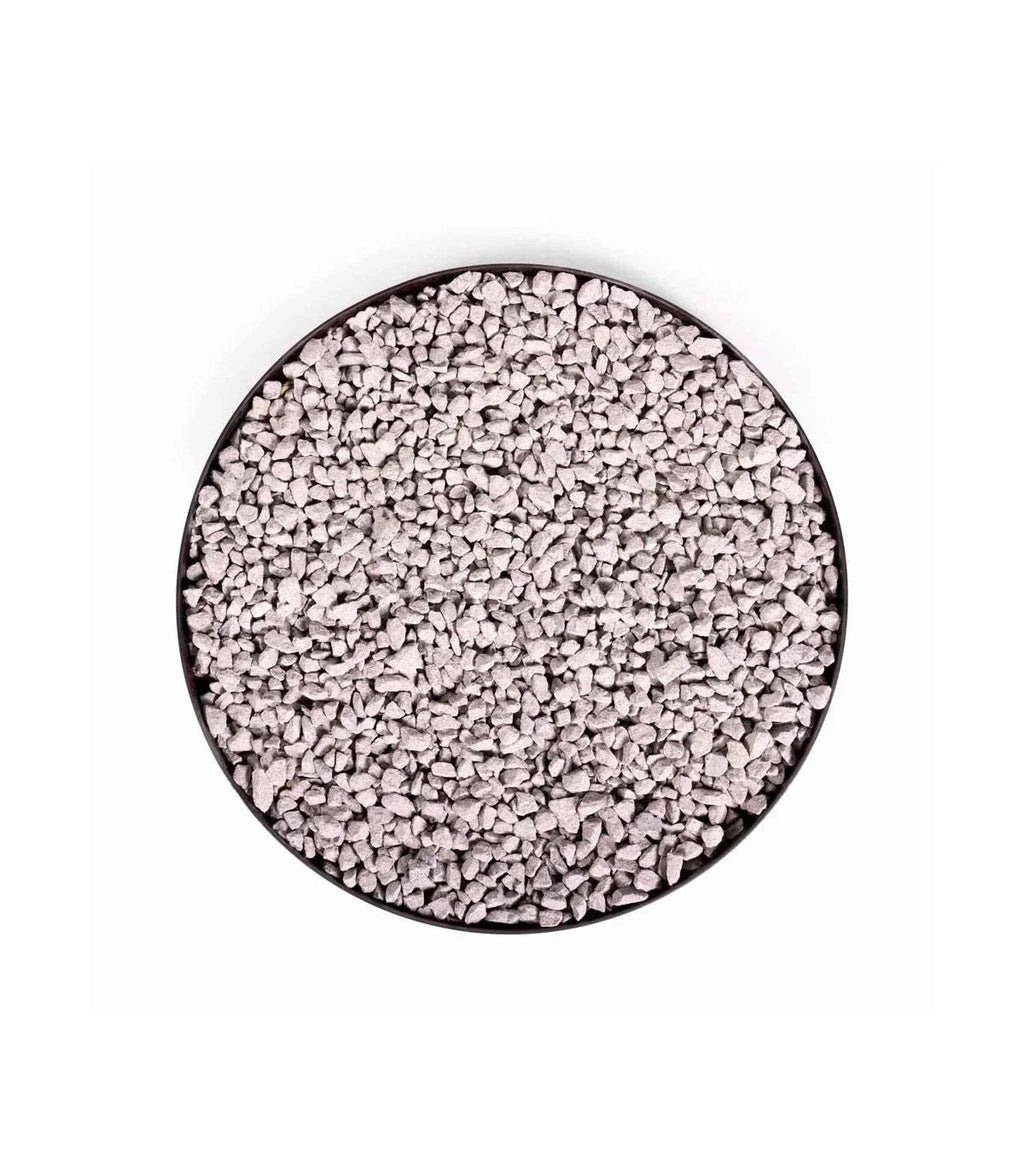 Perles polymères granulaires blanches dans un récipient circulaire noir.
