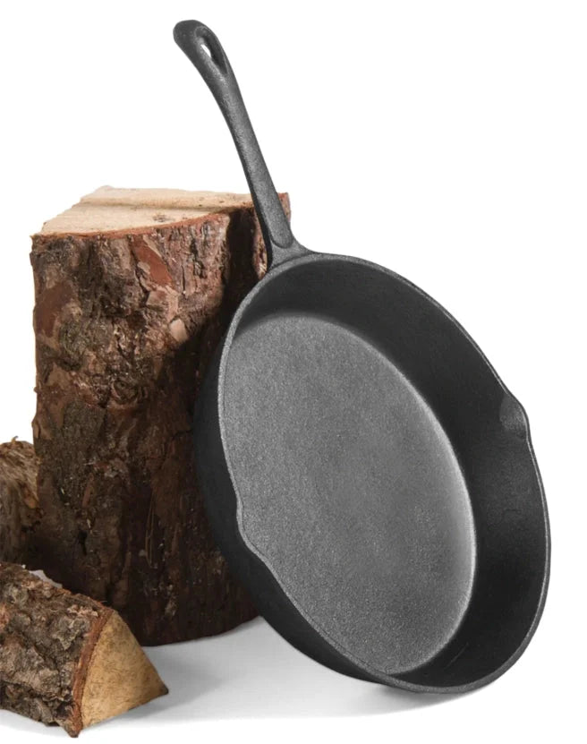 Poêle en fonte avec poignée courbée et finition noire, adaptée à la cuisson en extérieur.