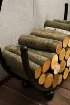 Rangement pour bûches en bois avec cadre métallique courbé et siège rembourré vert.