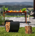 Organiseur de bois de chauffage noir avec design courbé et cadre métallique robuste, retenant des bûches empilées soigneusement.