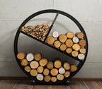 Support à bois circulaire noir avec trois compartiments, chacun contenant différents types de bois et d’allume-feu.