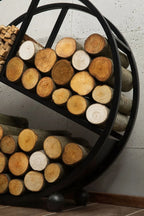 Support à bûches rond noir avec des bûches en bois
