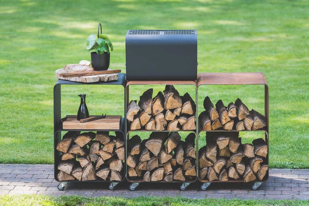Chariot de rangement pour bois de chauffage noir avec roues et étagères, contenant des bûches empilées soigneusement.