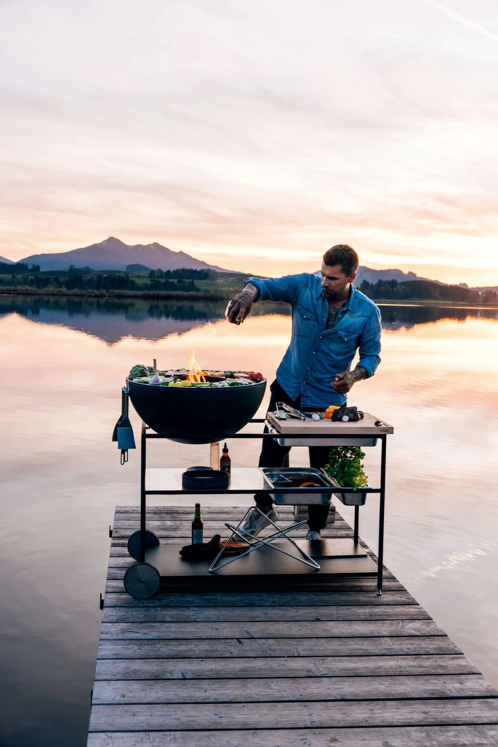 Barbecue au charbon avec un couvercle bleu et une grille noire, conçu pour la cuisson en extérieur.