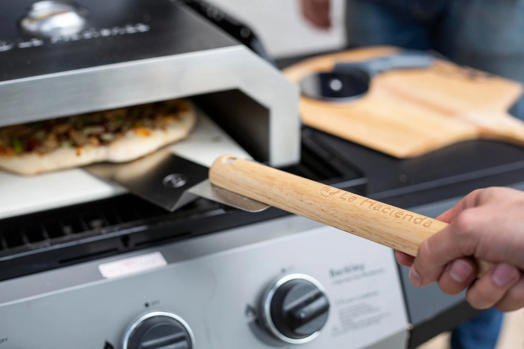 Pelle à pizza à manche en bois avec gravure de la marque « la piccioletta », présentant une finition lisse brun clair et une lame en métal robuste.