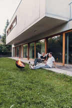 Foyer de feu noir et orange avec un design moderne, probablement du big green egg.