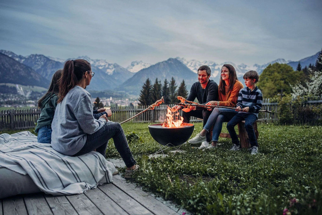 Foyer de feu rond noir avec poignées en bois et grille en métal