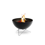 Foyer de feu noir avec des jambes de trépied modernes et un design en bol, inspiré par le boma.