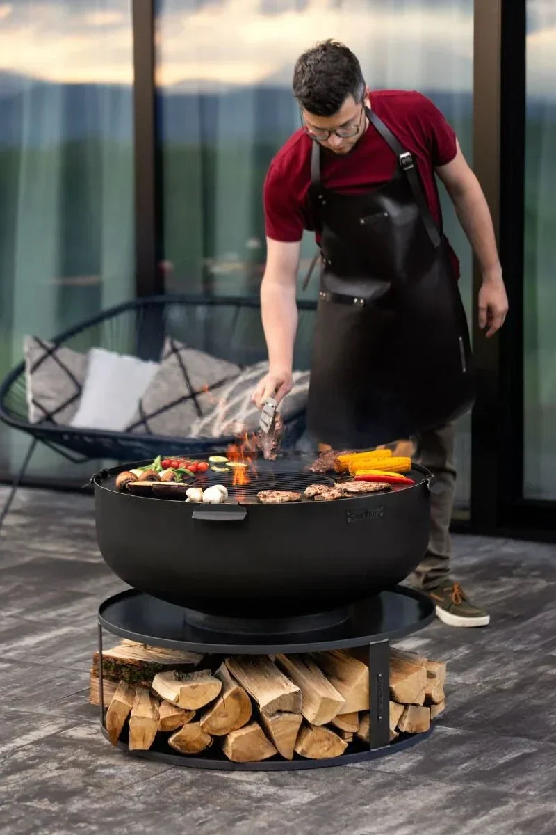 Autocuiseur en fonte noire avec poignées en bois et un couvercle, conçu pour la cuisson en extérieur.
