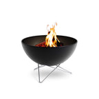 Foyer de feu noir en forme de bol avec des pieds en métal et un design moderne.
