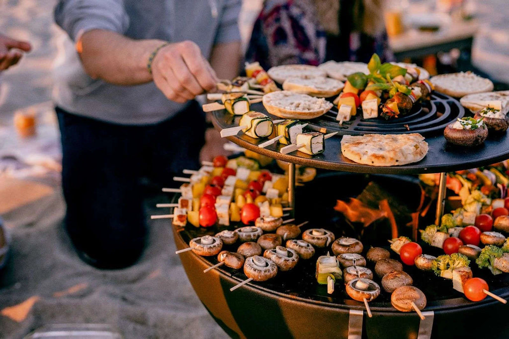 Grill barbecue avec plusieurs niveaux et divers aliments sur brochettes.