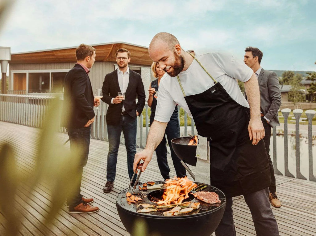 Barbecue au charbon avec bol noir et grille argentée.