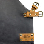 Tablier en cuir avec marque ’yakiniku’ et quincaillerie en laiton, de couleur gris foncé ou noir.