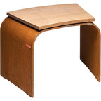 Tabouret en bois avec pieds et siège courbés, couleur brun clair, finition bois naturel.