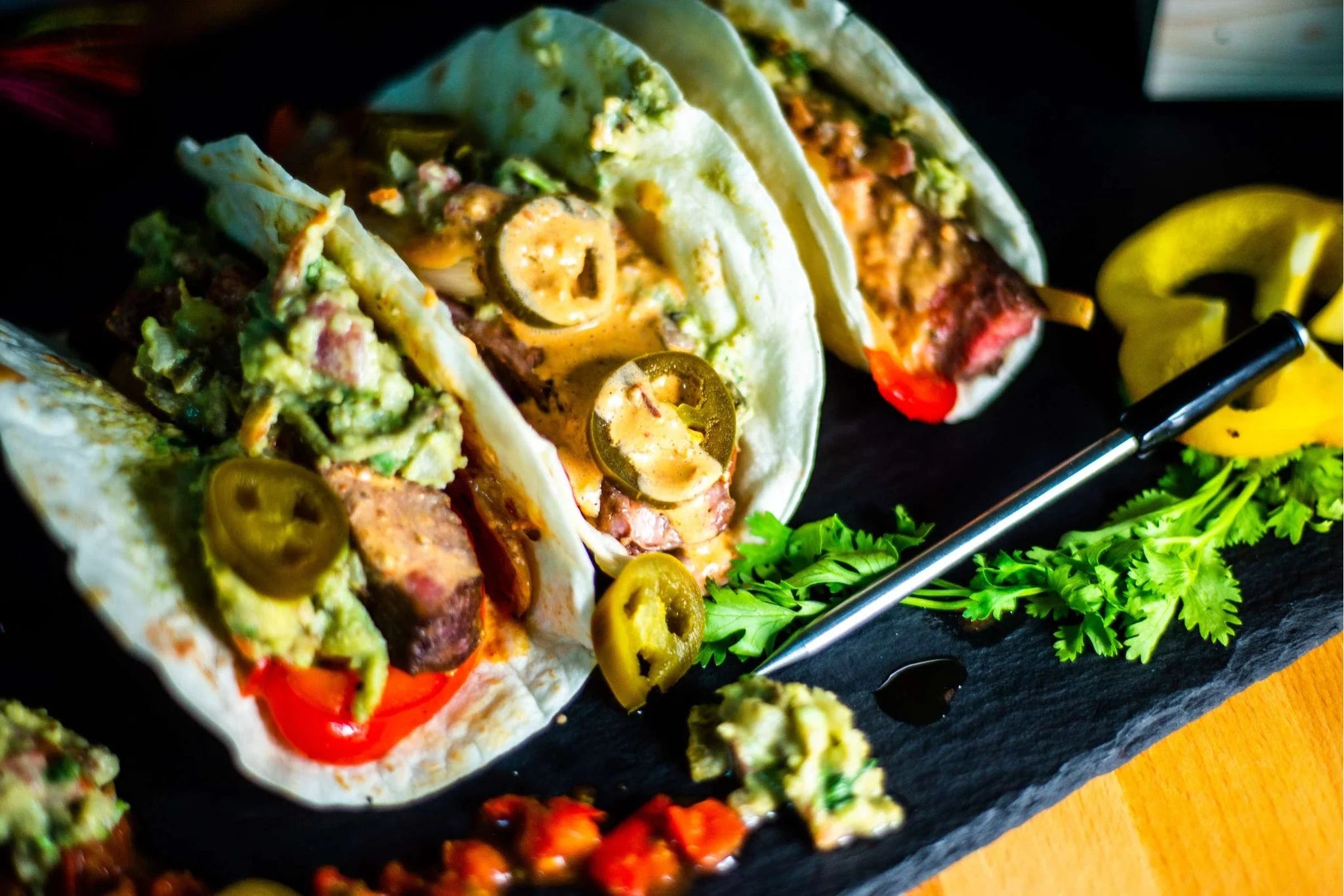 Couteau noir et argent avec un manche en bois, conçu pour couper les tortillas.