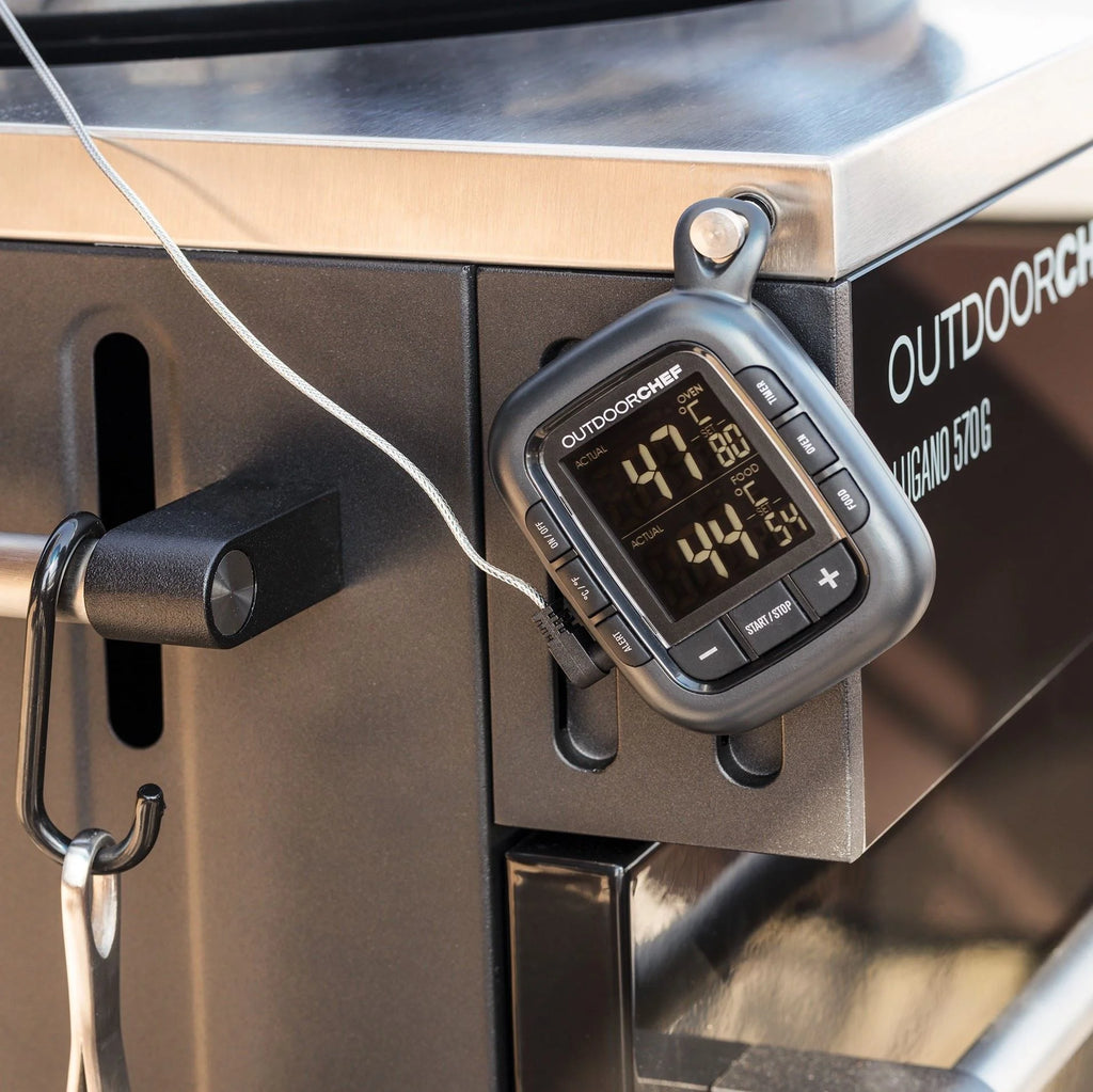 Thermomètre numérique argenté avec affichage et boutons noirs, monté sur une grille en acier inoxydable.