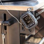 Thermomètre numérique argenté avec affichage et boutons noirs, monté sur une grille en acier inoxydable.