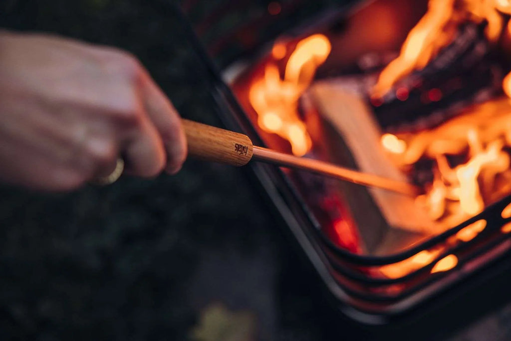 Brochette de barbecue à manche en bois avec une poignée marron foncé et une tige beige clair, conçue pour la cuisine en extérieur.