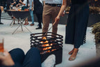 Foyer de feu en métal noir avec design circulaire et écran en maille.