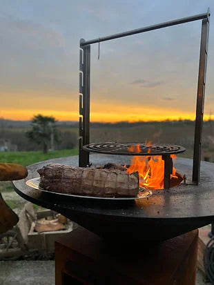 Tournebroche brasero inox avec flamme orange et viande rôtie