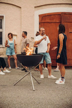 Barbecue au charbon avec support en métal et feu.