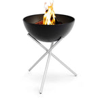 Foyer de feu en bol noir avec pieds en acier inoxydable et design moderne.