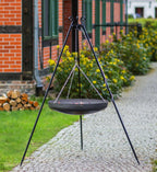 Foyer de feu en métal noir avec chaînes et pieds trépied.