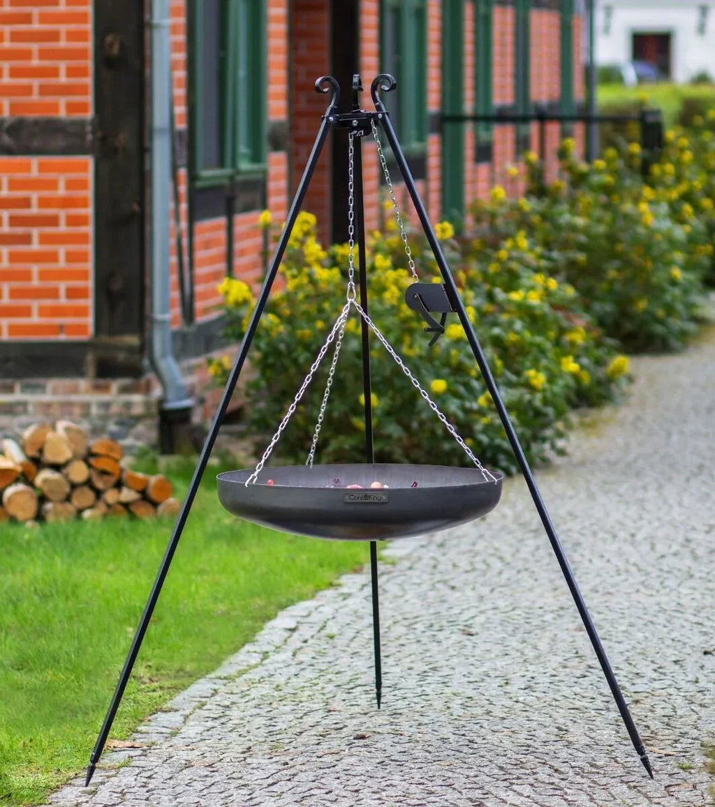 Foyer de feu sur trépied noir avec chaînes et design de bol, probablement en construction métallique.