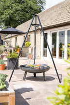 Support de gril trépied en métal noir avec grille de cuisson suspendue et des aliments dessus